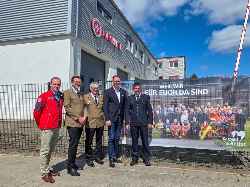Bei der Einweihung wurde außerdem das Banner „Respekt für Retter“ aufgehängt: Jan Carstensen (Wachleiter), Yonathan Arnold, Hans-Martin Grusnick (Mitglieder im Regionalvorstand), Bürgermeister Jan Lindenau und Thomas Köstler (Leiter Berufsfeuerwehr) (v.l.).
