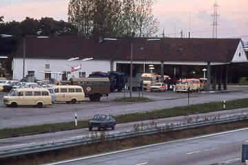 Rettungsfahrzeuge der Johanniter vor einem Gebäude direkt neben der Autobahn.