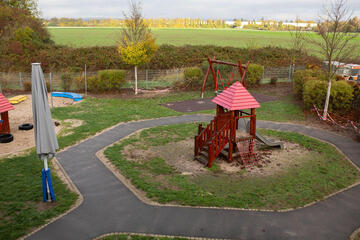 Blick auf das Außengelände der Kita mit Spielmöglichkeiten wie einer Rutsche