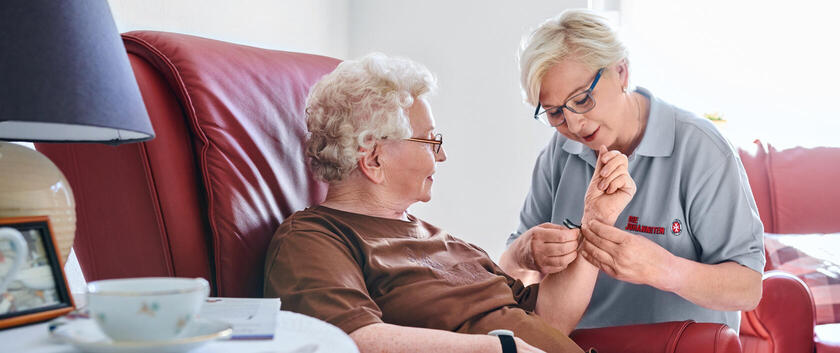 Eine Frau hilft einer älteren Dame