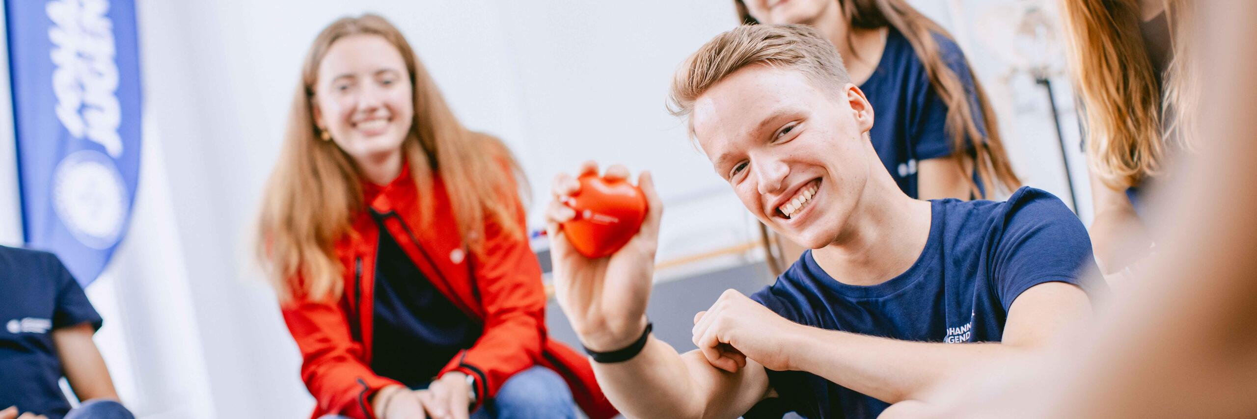 Johanniter-Mitarbeiter erklärt Jugendlichen etwas zu Erster-Hilfe