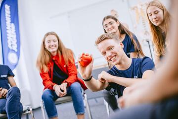 Johanniter-Mitarbeiter erklärt Jugendlichen etwas zu Erster-Hilfe