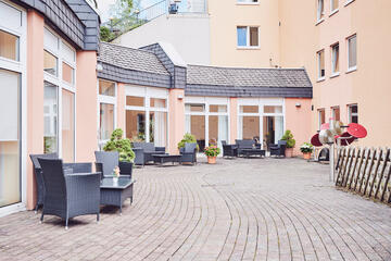 Blick auf die Terasse mit Sitzgelegenheiten und Sportgeräten