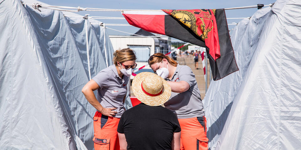 zwei Sanitäter kümmern sich um einen verletzten Festivalbesucher