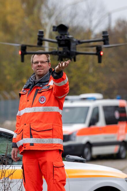 Ein Mann in Einsatzkleidung mit einer vor ihm schwebenden Drohne