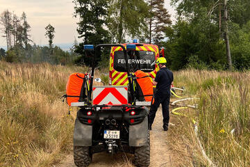 Ein Quad steht bei einem Einsatz hinter einem Fahrzeug der Feuerwehr. 