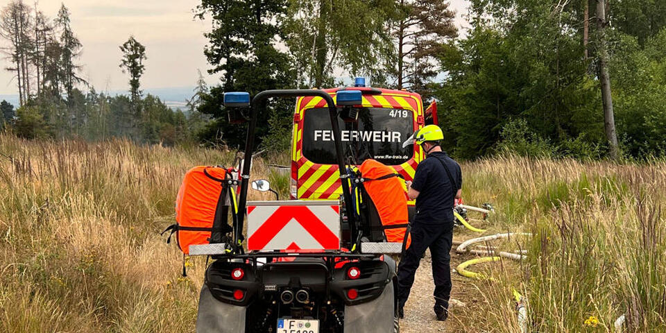 Ein Quad steht bei einem Einsatz hinter einem Fahrzeug der Feuerwehr. 