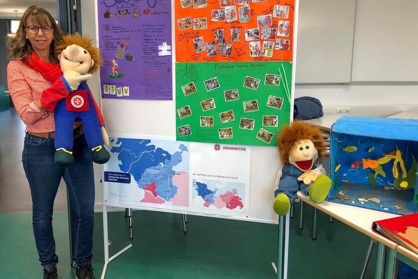 Ilka Lambke, Leiterin der Johanniter-Kita Stoppelhopser Am Steinfelder Redder, informierte die Schülerinnen und Schüler der Berufsschule vor allem über die Blaulichtzwerge, Nachhaltigkeits- und Kunstprojekte. Sie hält eine der Puppen hoch, die bei den Blaulichtzwergen zum Einsatz kommen.
