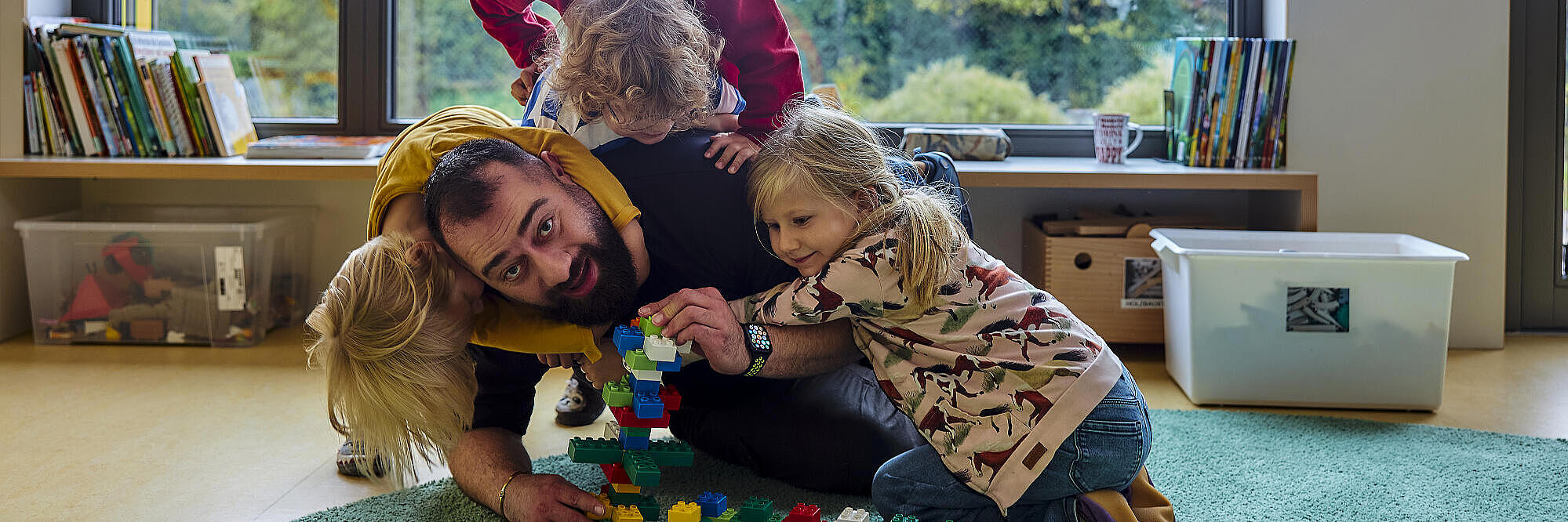 Kita-Mitarbeiter spielt mit Kindern