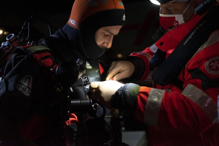 David Runde, ehrenamtliches Mitglied der Johanniter-Tauchergruppe, wird für seinen nächtlichen Taucheinsatz vorbereitet.