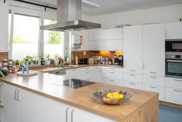 Eine weiße Küche mit brauner Arbeitsfläche und einer Halbinsel