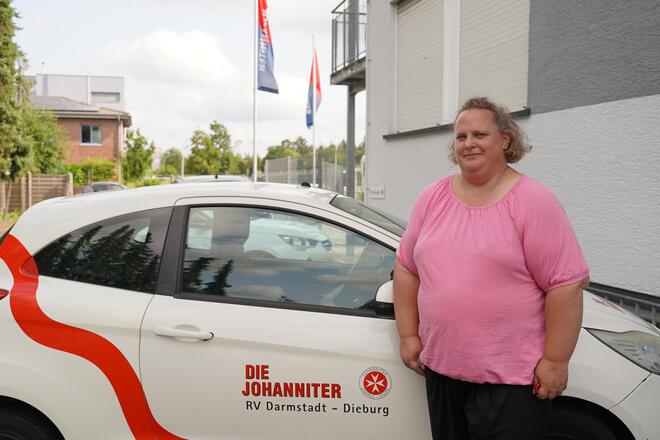 Simone Gutheil vor einem Fahrzeug der ambulanten Pflege