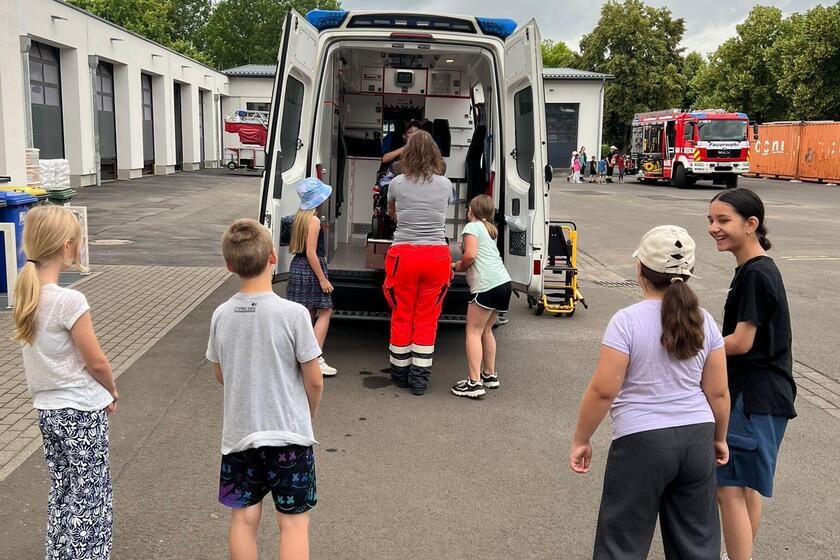 Schulkinder interessiert vor geöffnetem RTW-Innenraum