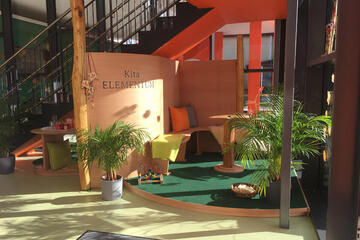 Gemütlicher Sitzbereich für Eltern im Eingangsberich der Kita Elementum. 