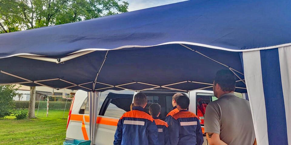 Kinder schauen in ein Johanniter-Fahrzeug