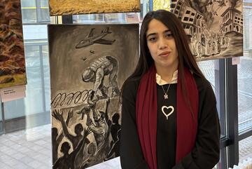 Marmarin Bagi mit ihrem Bild aus Afghanistan: Ein Baby wird einem abfliegenden Soldaten zum Mitnehmen über den Zaun gereicht.