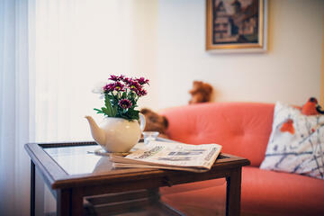 Eine kleine rote Blume auf einem Glastisch im Johanniter-Haus Empelde