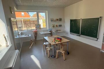 Lernraum mit Tafel und Stühlen/Tisch
