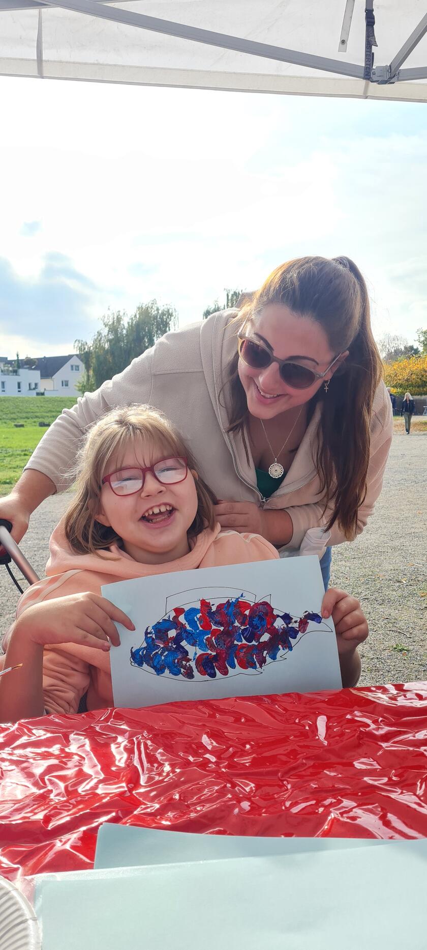 Kind mit Beeinträchtigung und Betreuerin bei gemeinsamer Malaktion