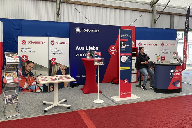 Am Johanniter-Infostand auf dem Maimarkt 2026 stellen die Johanniter u.a. die Hausnotrufgeräte aus, bieten diverse Infoblätter und einen Memory-Spiel für Kinder an.