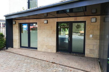 Zwei Eingangstüren, eine davon mit dem Logo des Argentums am Ried. 