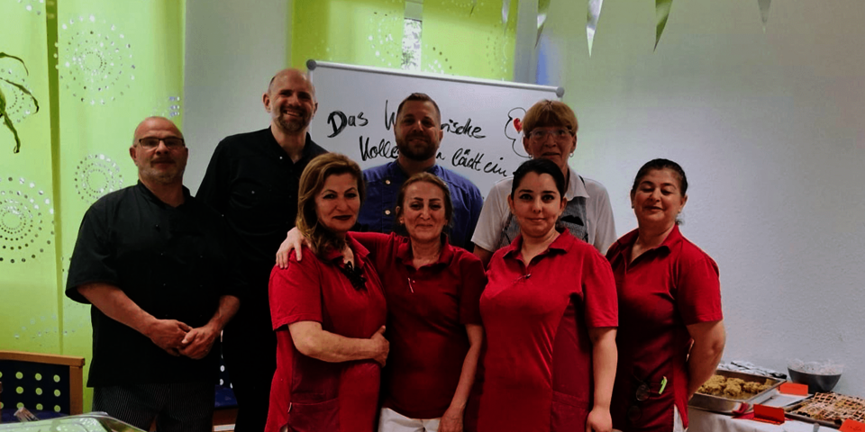 acht Personen neben einem Buffettisch