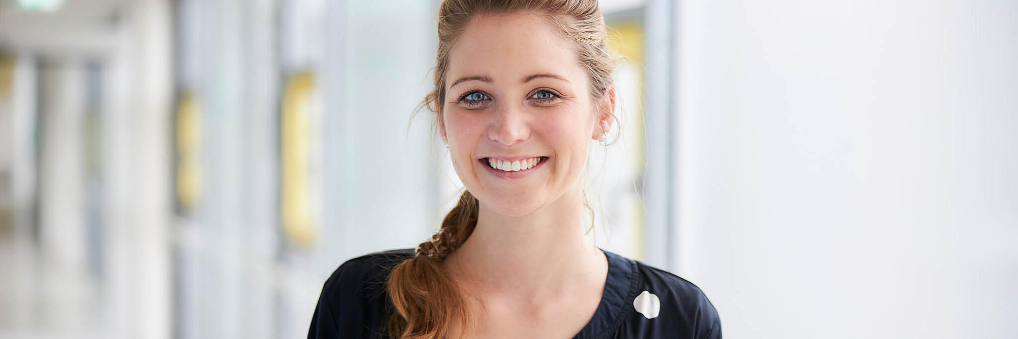 Eine junge Frau lacht in die Kamera