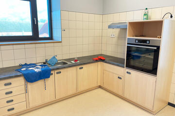 Eine aufgeräumte Küchenzeile mit Ofen, Herd und Spüle für Kinder.