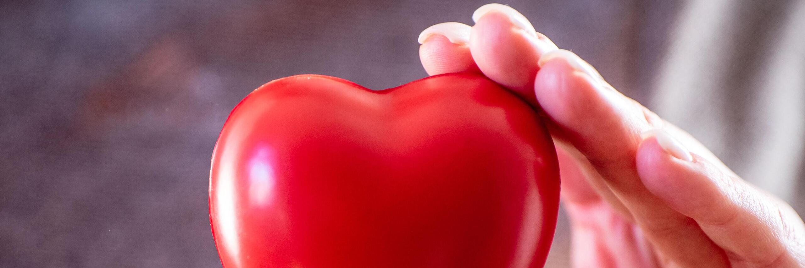 Eine Hand hält ein rotes Herz