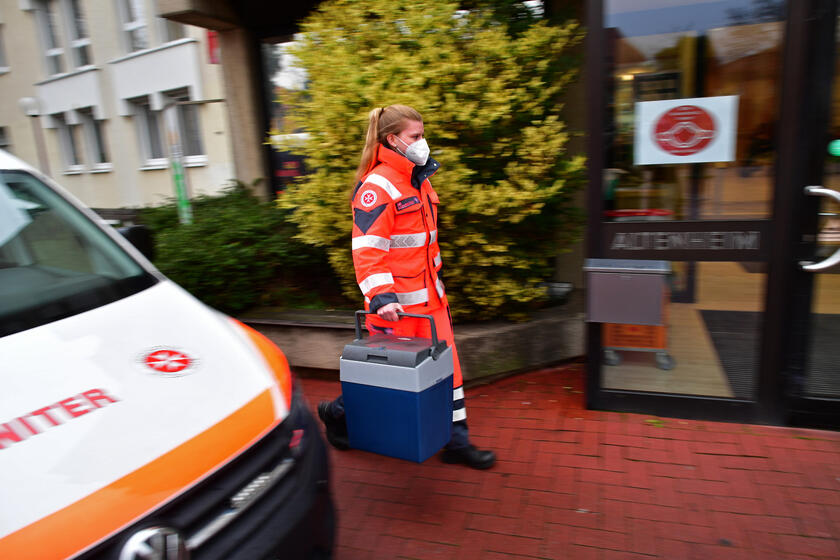 Eine Mitarbeiterin der Johanniter liefert Corona-Impfstoff in eine Senioreneinrichtung.