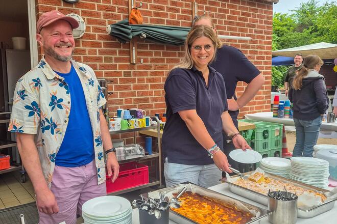 Sommerfest der Kitas Wilde 13 und Kleine Wilde Zwei Mitarbeitende der Kitas Kleine Wilde und Wilde 13 stehen hinter dem Kuchenbuffet.