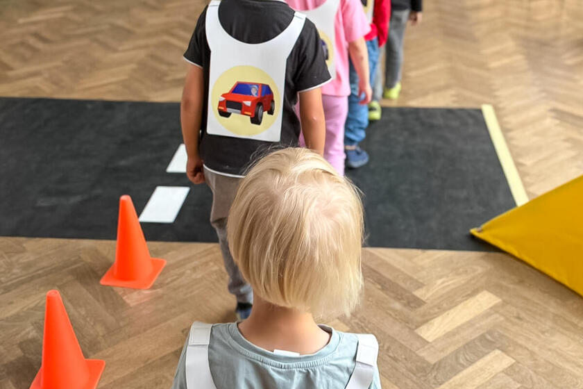 Mehrere Kinder gehen hintereinander einen Parcours entlang.