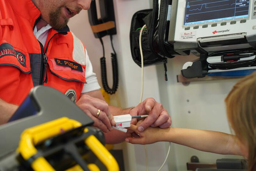 Notfallsanitäter misst bei einem Kind den Blutdruck