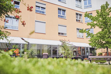 Sicht zur gemütlichen Innenhofseite und den überdachten Sitzbereichen des Johanniter-Hauses Köln Zollstock.