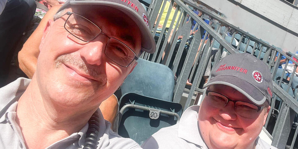 Zwei Johanniter auf einer Zuschauertribüne