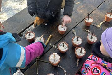 Kinder stellen Vogelfutterplätze her.