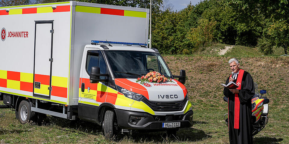 Das Einsatzfahrzeug zum Transport der mobilen Arztpraxis wird von einem Pfarrer gesegnet.