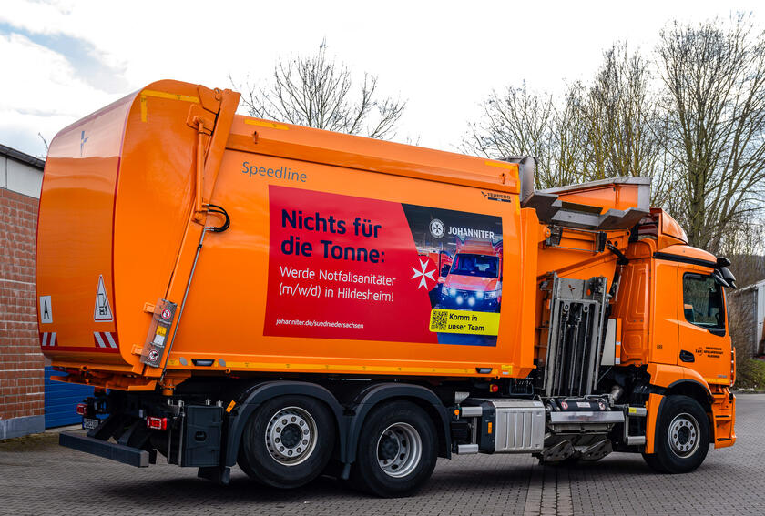 Ein Müllwagen, der beklebt ist mit "Nichts für die Tonne: Werde Notfallsanitäter (m/w/d) in Hildesheim!"