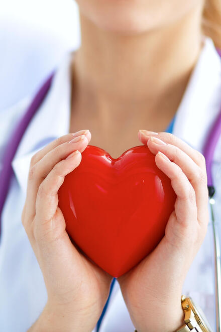 Ärztin mit rotem Herz in der Hand 