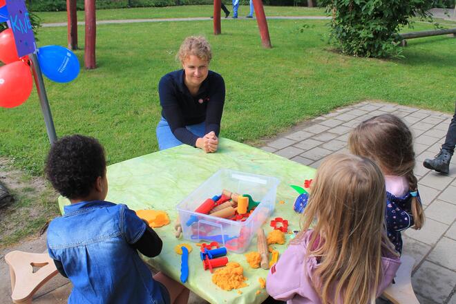 Eine Frau mit Kindern an einem kleinen Tisch