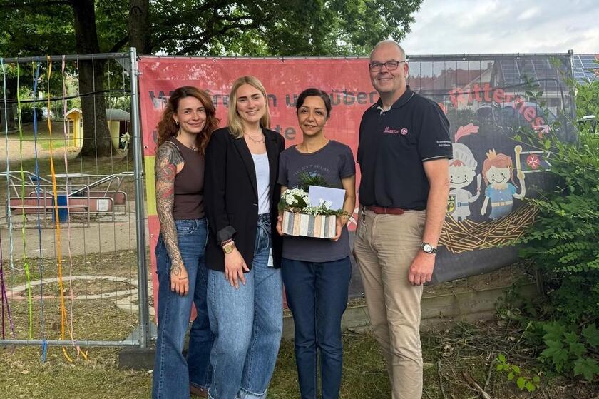 vier Personen mit Präsentkorb