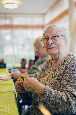 Aus buntem Papier basteln Bewohnerinnen Blumenschmuck