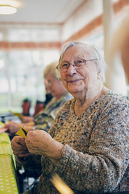 Aus buntem Papier basteln Bewohnerinnen Blumenschmuck
