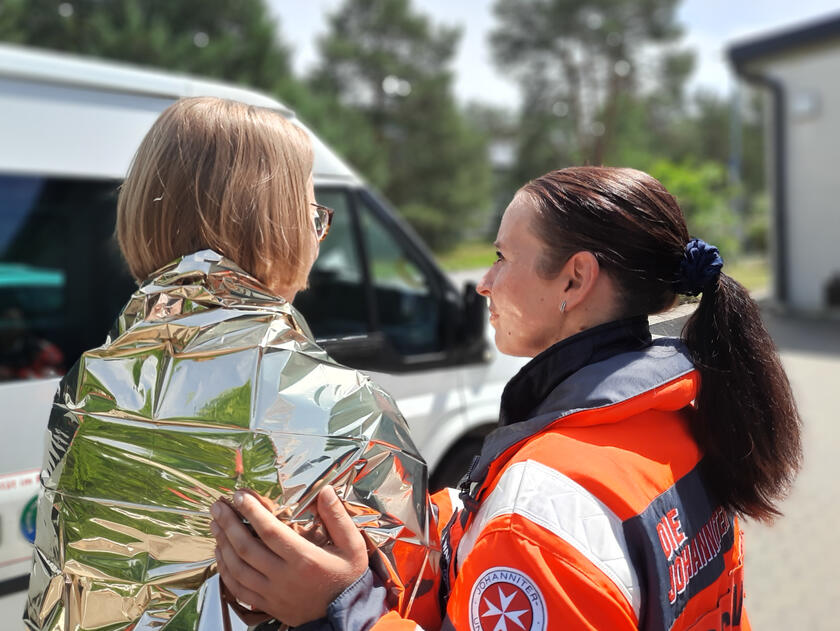 Eine ehrenamtliche Krisenhelferin des PSNV spendet einer Frau Trost.