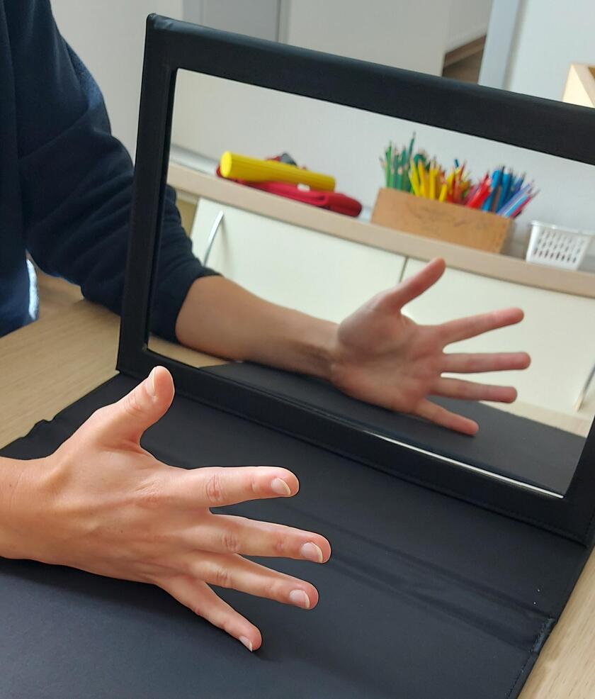 Eine Hand wird vor einem Spiegel bewegt.