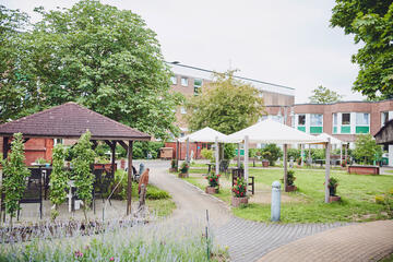 Garten mit Gartenmöbel im Johanniter-Stift Heuserhof in Köln.