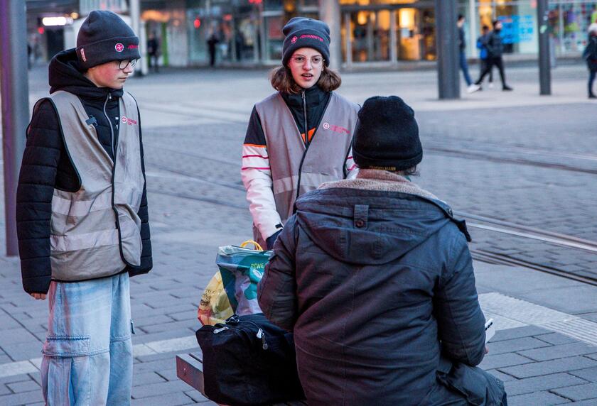 Jugendliche der Johanniter-Jugend im Gespräch mit einem wohnungslosen Mann