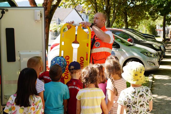 Notfallsanitäter zeigt Kindergartenkindern den Inhalt des RTWs