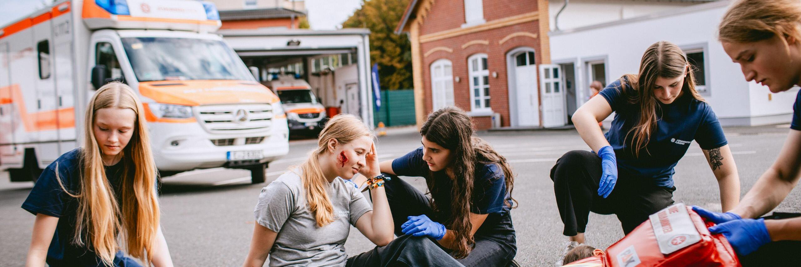 Jugendliche versorgen eine verletzte Schülerin