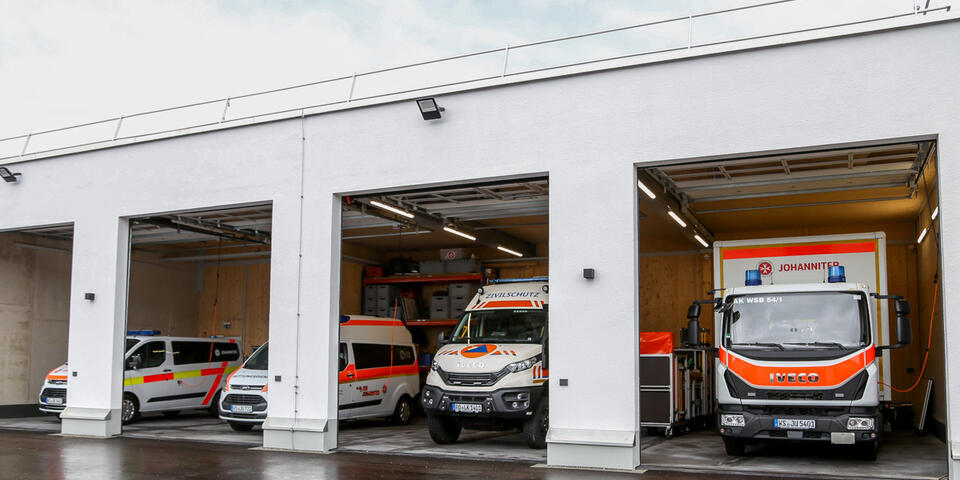 Johanniter-Fahrzeuge in moderner Garage bereit für den Einsatz